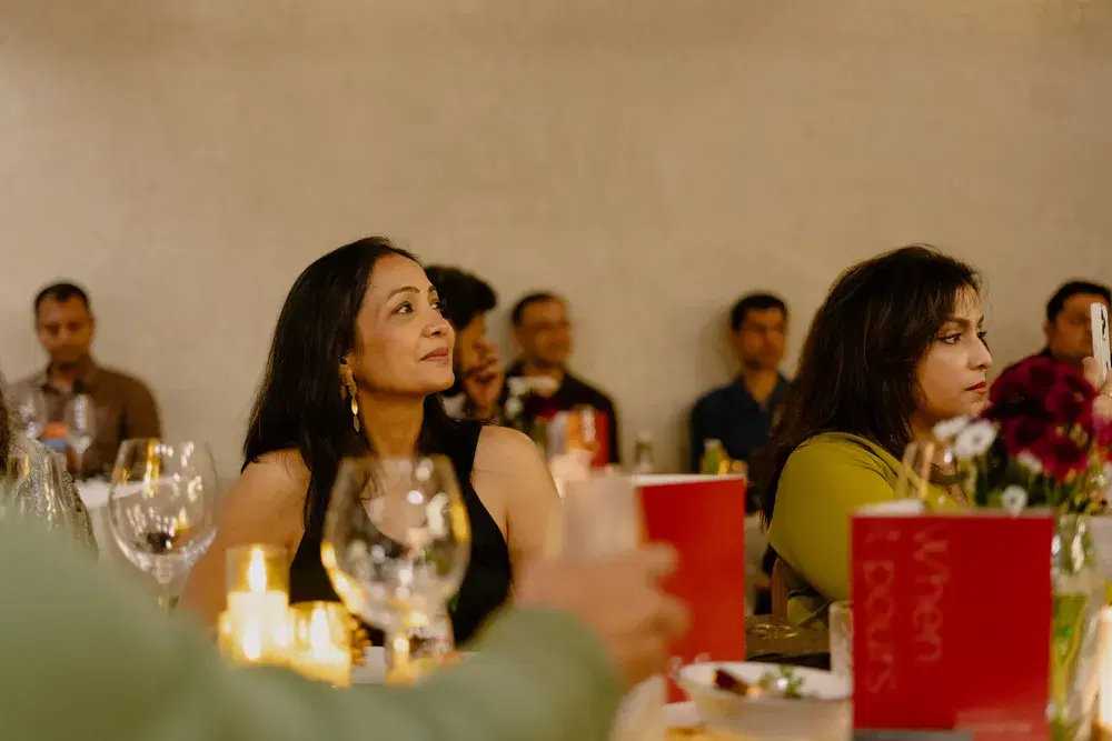 Guests in conversation by candlelight at a Postcard supper