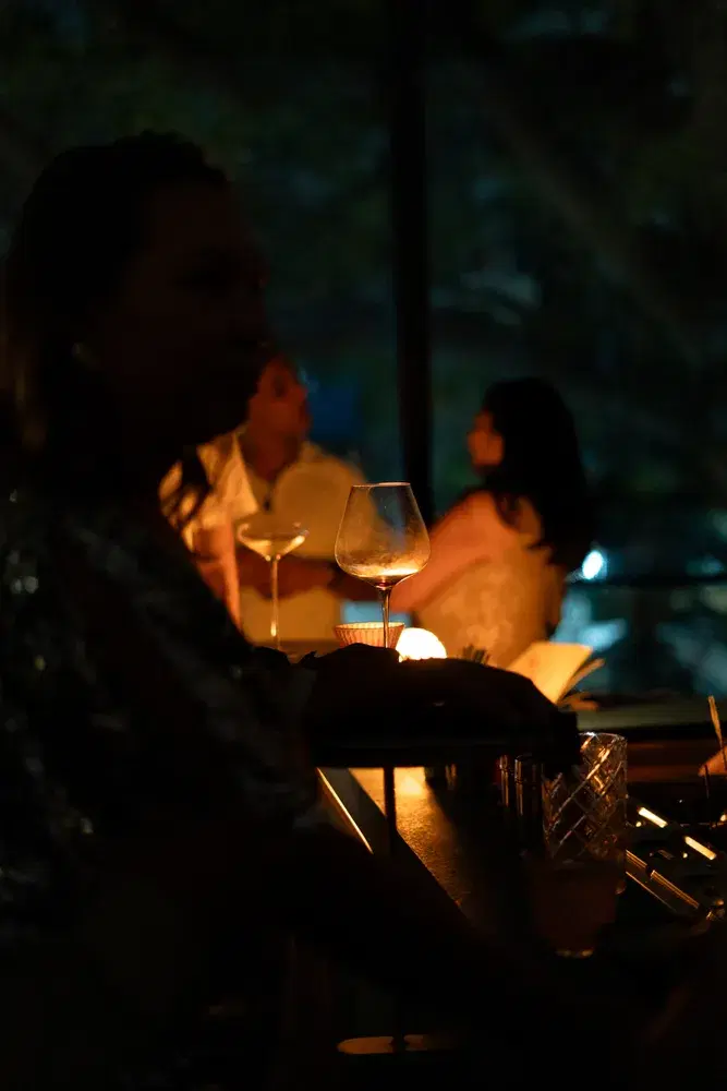 Members gathered around a candlelit bar in the evening